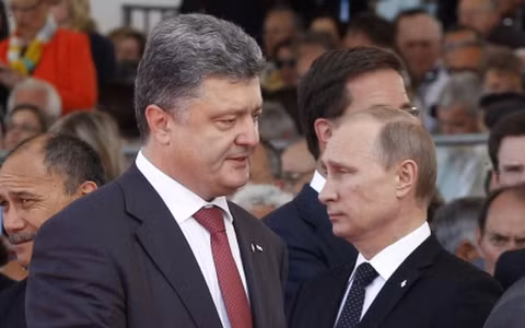 Tổng thống Ukraine Poroshenko (trái) và người đồng cấp Nga Putin trong lần gặp mặt đầu tiên tại lễ kỷ niệm ngày D-Day tháng 6 vừa qua (Ảnh AFP)