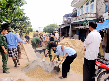 Các cán bộ, chiến sĩ biên phòng giúp dân xã đảo Vĩnh Thực làm đường giao thông nông thôn.