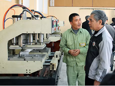 Anh Lê Minh Sơn (bên phải) chỉ dẫn cho các học viên tại Trung tâm học nghề.