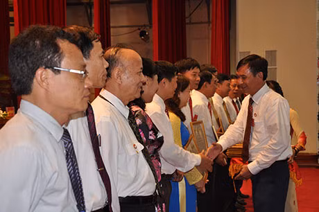 Đồng chí Nguyễn Ngọc Minh Chủ tịch Ủy ban MTTQ tỉnh khóa IX trao bằng khen của UBND tỉnh cho các tập thể có thành tích xuất sắc trong công tác mặt trận nhiệm kỳ qua