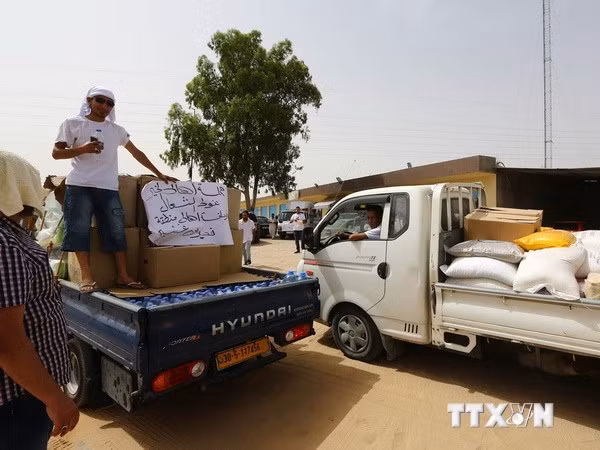  Xe chở hàng cứu trợ phân phát cho người dân tại Qasr bin Ghashir, gần sân bay quốc tế ở Tripoli. (Nguồn: AFP/TTXVN)