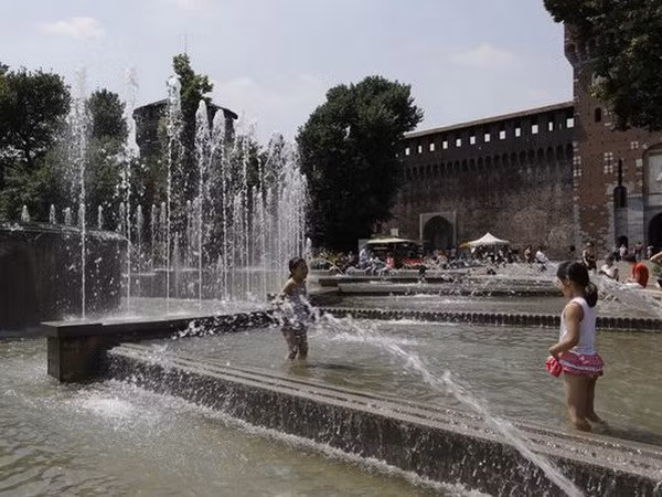 Hai bé gái chơi đùa với nước tránh nóng ở Milan, Italy. (Nguồn: AP)