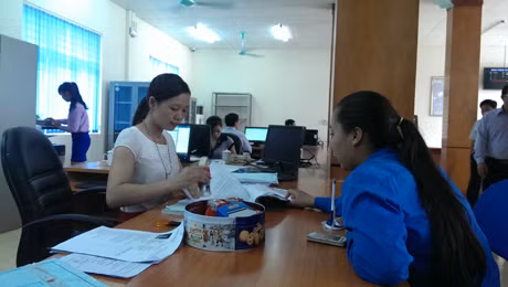 Cán bộ Trung tâm hành chính công huyện Vân Đồn hướng dẫn người dân làm thủ tục.