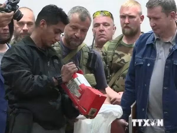 Một quan chức Malaysia kiểm tra hộp đen của máy bay MH17 sau khi nhận bàn giao ở Donetsk. AFP-TTXVN