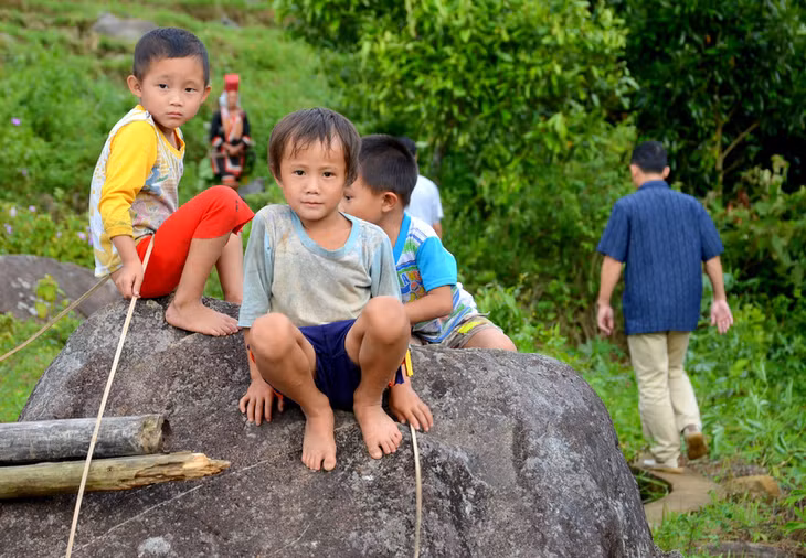 Ánh mắt ngây thơ, hồn nhiên của mấy cậu bé đang nô đùa trên mỏm đá lưng chừng núi
