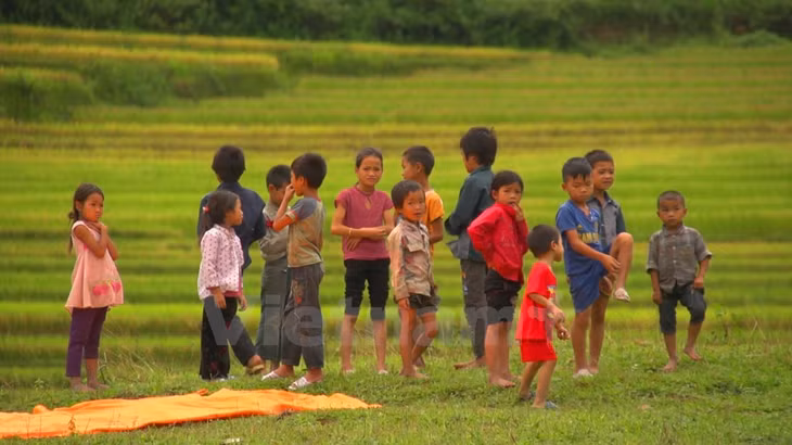 Trẻ em chờ đón phi công ở bãi đáp dưới chân đèo Khau Phạ... (Ảnh: Tùng Lâm/Vietnam+)