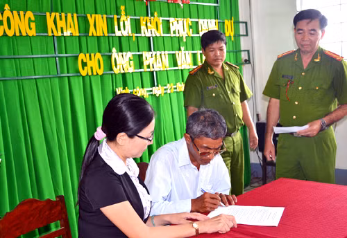 Ông Lá ký biên bản nhận bồi thường. Ảnh: Minh Minh