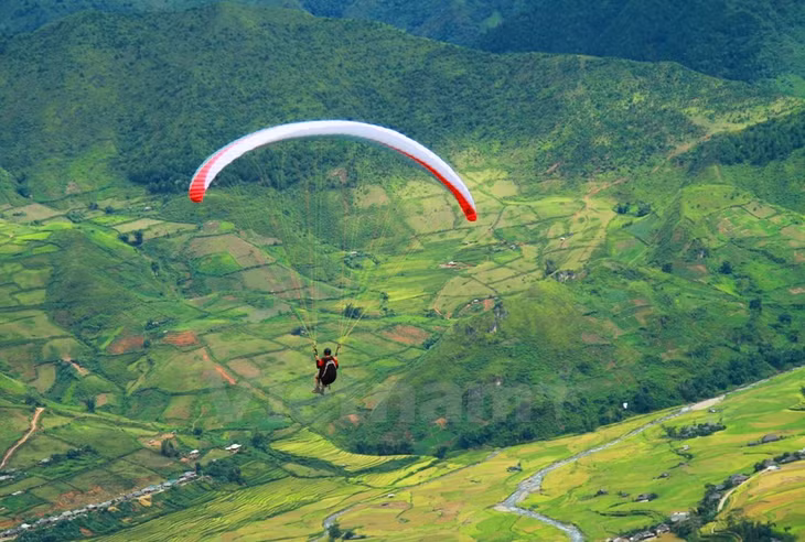 Mà còn ngây ngất trước bức tranh thơ mộng của những thửa ruộng bậc thang vàng óng như sóng xô chân núi biếc xanh.(Ảnh: Xuân Mai/Vietnam+)