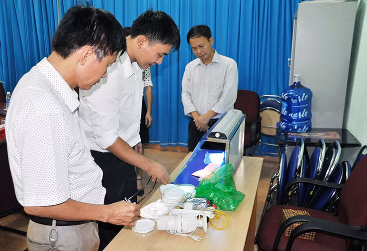 Tiến sĩ Đỗ Quang Trung (thứ 2, trái sang) giới thiệu đèn chuyên dụng cho cây trồng với đoàn khảo sát Hội thi STKT tỉnh lần thứ V.