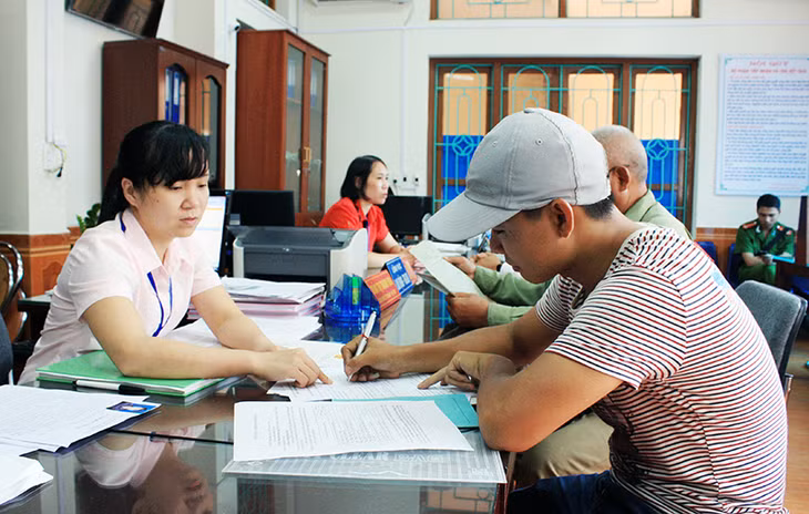 Cán bộ bộ phận “một cửa” phường Quang Trung (TP Uông Bí) hướng dẫn người dân đến làm thủ tục hành chính.