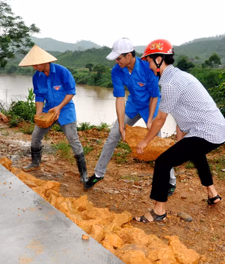 Dù trời đổ mưa nhưng các sinh viên vẫn quyết tâm giúp bà con.