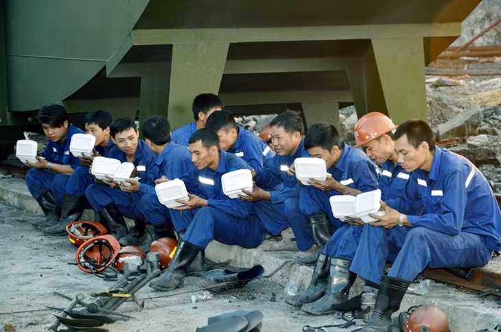 Công nhân Tập đoàn TKV tranh thủ ăn tối chờ đến phiên xuống lò cứu hộ.