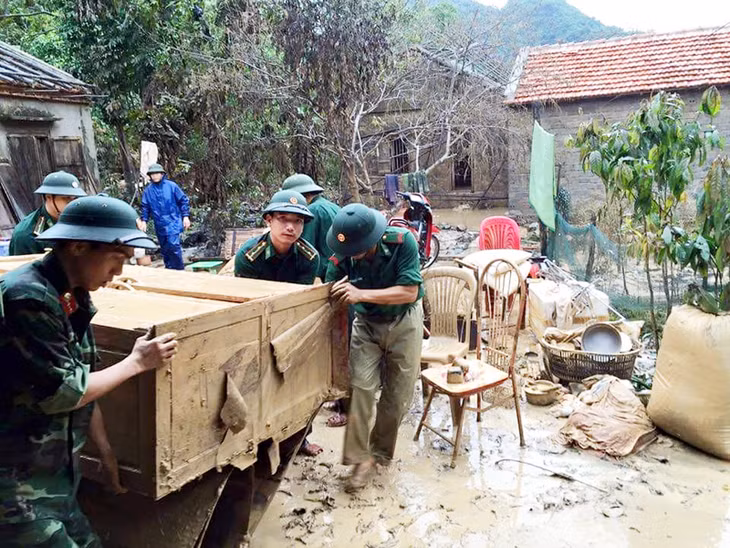 CBCS BĐBP tỉnh giúp nhân dân xã Bản Sen (Vân Đồn) dọn dẹp nhà cửa sau trận mưa lụt cuối tháng 7, đầu tháng 8-2015. Ảnh: Quốc Chiểu (BĐBP tỉnh)