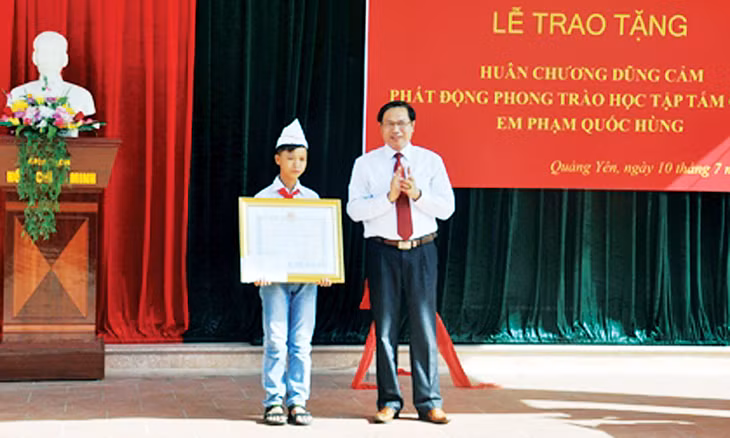 Lãnh đạo TX Quảng Yên trao Huân chương Dũng cảm của Chủ tịch nước cho em Phạm Quốc Hùng, tháng 7-2014.