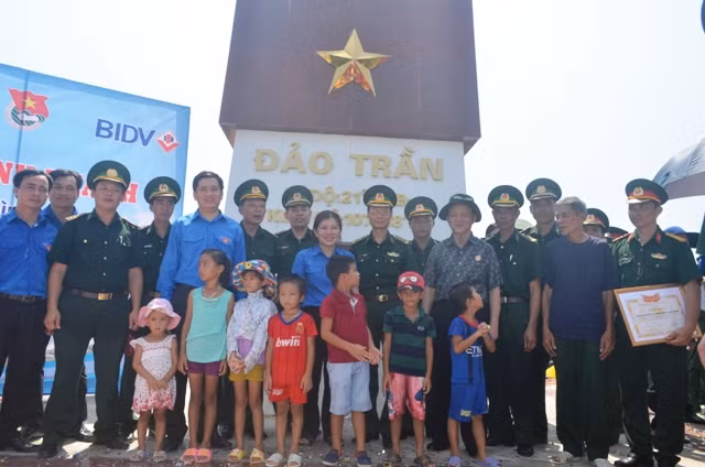 Đại biểu chụp ảnh lưu niệm cùng cư dân đảo Trần tại cột cờ đảo Trần