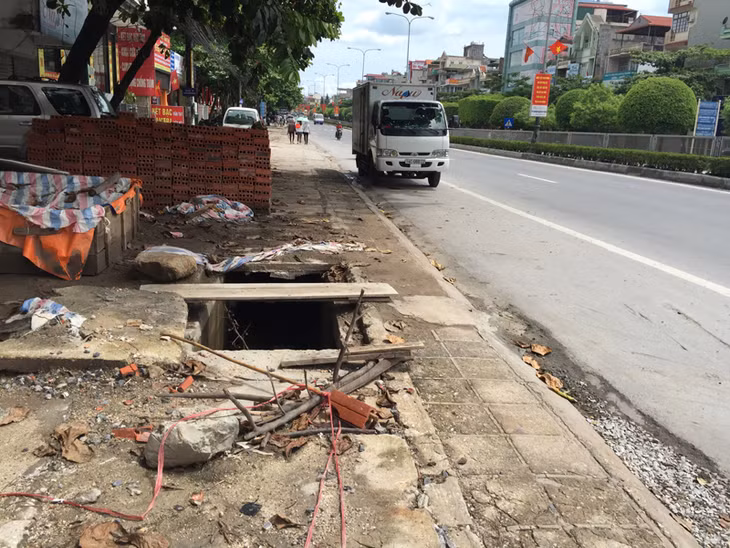 Nắp cống được cảnh báo bằng cành cây tạm bợ ngay gần trụ sở UBND phường Hồng Hải.