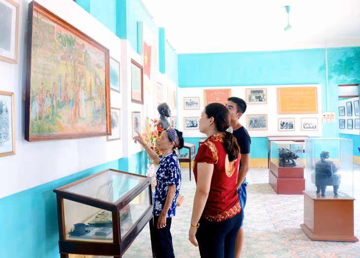 Bà Trần Thị Trân (đứng trước) giới thiệu những hiện vật trong Nhà trưng bày truyền thống Chiến khu Đông Triều.
