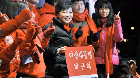 Ứng viên đảng cầm quyền Park Geun-hye cầm biểu ngữ có dòng chữ "Nữ tổng thống Park Geun-hye" tại một cuộc vận động tranh cử ở Seoul hôm qua. Ảnh: AFP
