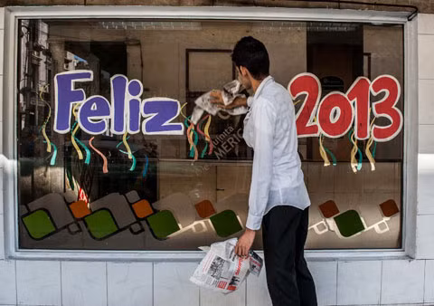 Một công nhân lau ô cửa kính trang hoàng đón năm 2013 ở thủ đô Havana của Cuba.