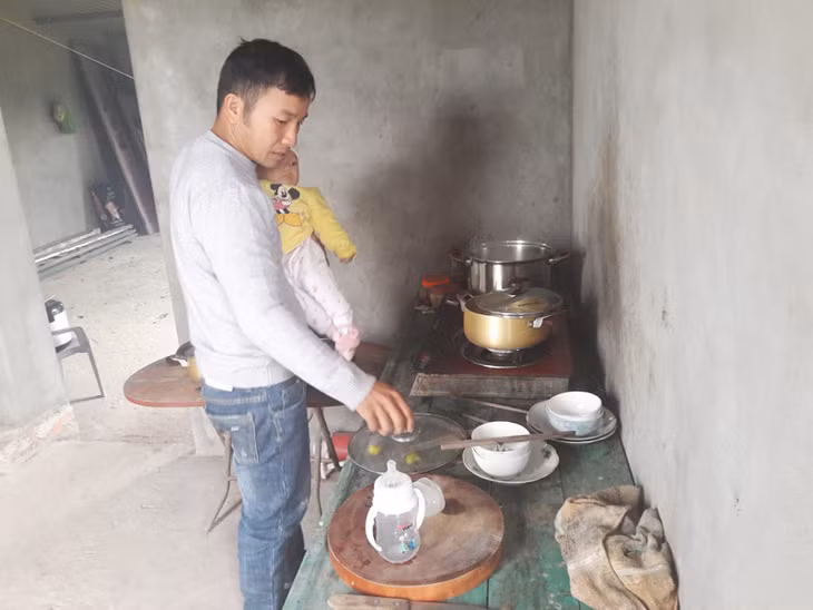 Anh Từ Văn Seo phải vừa bế con vừa nấu cháo cho con