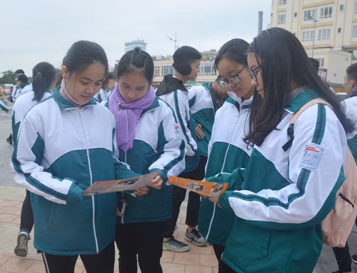 Các học sinh đọc thông tin tuyên truyền về phòng chống HIV/AIDS