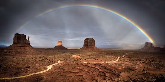 Tác phẩm "Rainbow over Monument Valley" của tác giả Frederic Huber vào top ảnh đẹp hạng mục Amateur Nature/Landscapes, chụp hình ảnh cầu vồng trên bầu trời ở thung lũng Monument, bang Arizona, Mỹ.