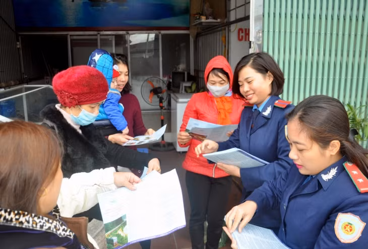 ĐVTN phát tờ rơi kết hợp với tuyên truyền miệng cho người dân phường Đại Yên (TP Hạ Long) các quy định về đảm bảo hành lang ATGT đường bộ, đường sắt.