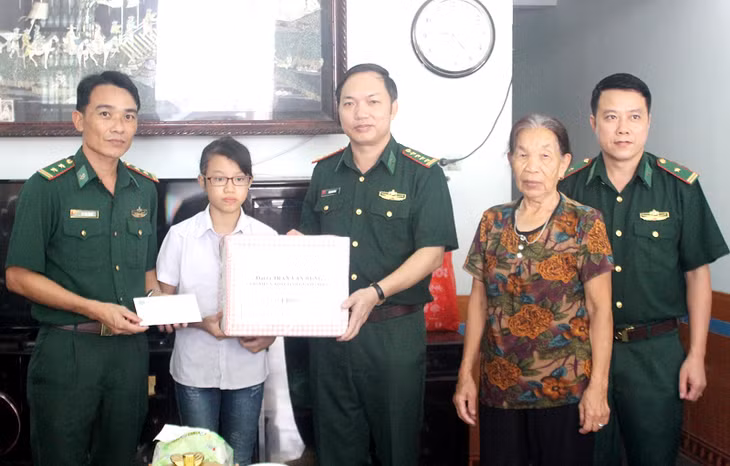 Đại tá Trần Văn Bừng, Chính ủy BĐBP tỉnh Quảng Ninh cùng đại diện Đồn Biên phòng Bắc Sơn trao quà cho em Trần Thúy Na, học sinh lớp 7, trường THCS Ka Long (Ảnh: Vi Thu, CTV)