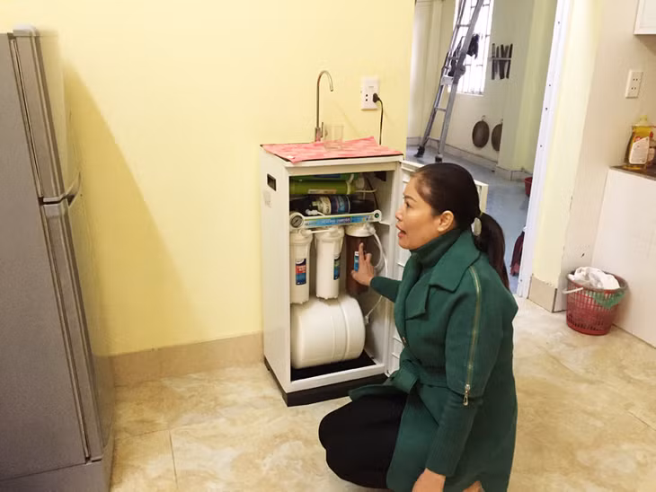 Bà Trần Thị Hường chỉ cho phóng viên xem mức độ ô nhiễm của nước giếng khoan mà gia đình đang sử dụng