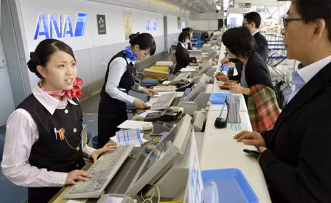 Các nhân viên hàng không giải thích với khách hàng về sự cố hoãn các chuyến bay tại sân bay Sendai. Ảnh: AP