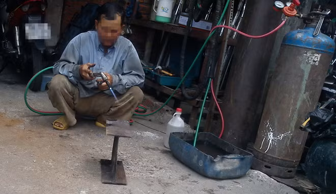 Trên đường Bình Long (Q.Tân Phú, TP.HCM), hàng chục cơ sở gia công sắt thép sử dụng bình gió đá đã gỉ sét có nguy cơ cháy nổ. Trong ảnh: một thợ dùng gió đá cắt sắt tại một cơ sở gia công sắt thép trưa 25-2