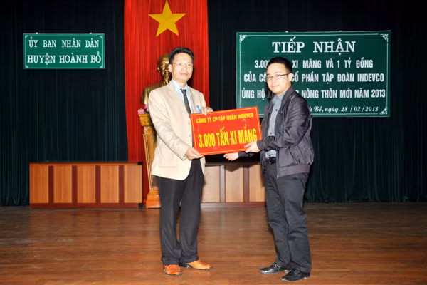 Ông Đỗ Tiến Dũng (bên phải) Phó Tổng Giám đốc Công ty Cổ phần Tập đoàn Indevco trao số xi măng và tiền ủng hộ cho đại diện lãnh đạo huyện Hoành Bồ.