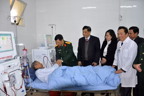 Đại tá Cao Đức Thành, Phó Tổng Giám đốc Tổng Công ty Đông Bắc (thứ nhất, trái sang) trao tặng máy chạy thận nhân tạo và thăm bệnh nhân đang điều trị tại Bệnh viện Đa khoa Cẩm Phả.