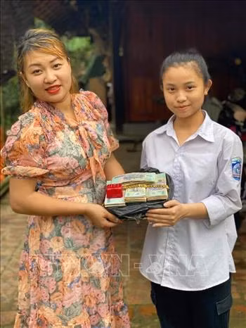 Chị Lê Thị Thắm vui mừng sau khi nhận lại số tài sản đã bị đánh rơi. Ảnh: TTXVN phát
