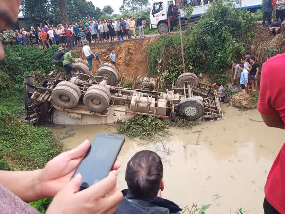  Chiếc xe bồn lật ngửa sau khi rơi xuống ao - Ảnh: HỒNG KHÔI
