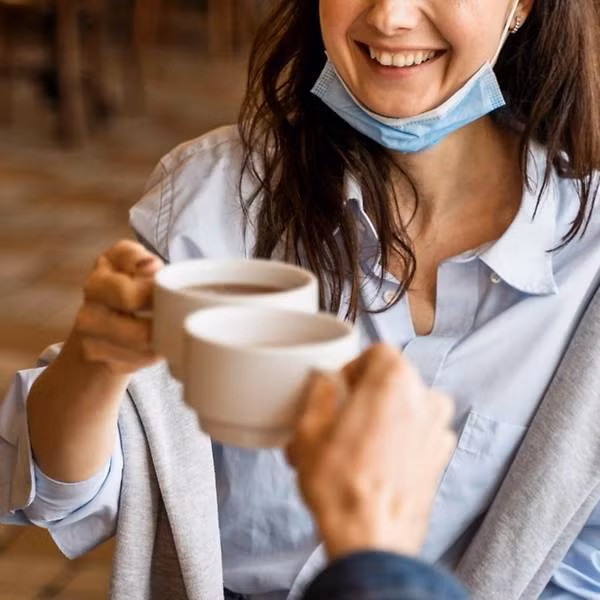 Kéo khẩu trang xuống cằm là thói quen có hại, dễ làm lây nhiễm COVID-19. Ảnh: CNA