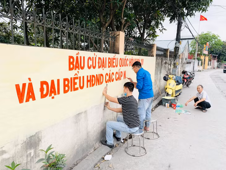 Đoàn thanh niên phường Cẩm Sơn vẽ tranh tường tuyên truyền về bầu cử.
