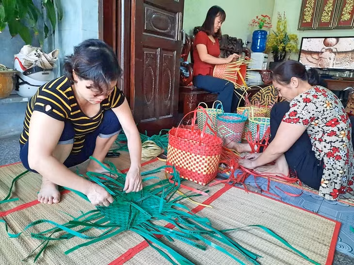 Phụ nữ phường Hà Trung tham gia đan làn từ những dây buộc gạch tái chế.