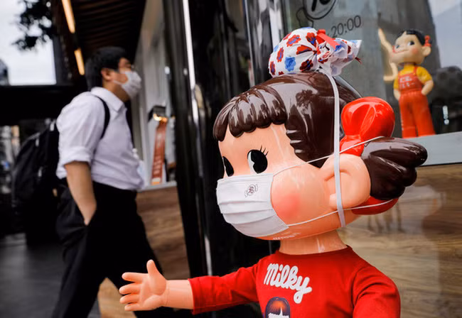 Manơcanh đeo khẩu trang được đặt bên ngoài một trung tâm mua sắm ở Tokyo ngày 22/4. Ảnh: Reuters