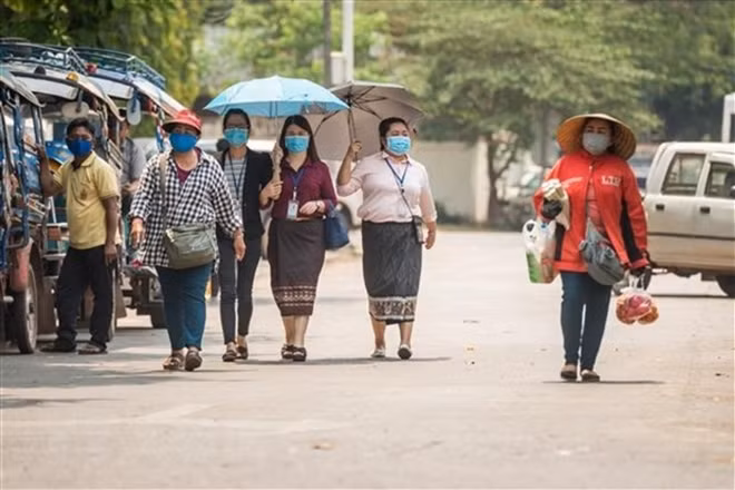 Người dân đeo khẩu trang phòng lây nhiễm COVID-19 tại Viêng Chăn, Lào. (Ảnh: THX/TTXVN)