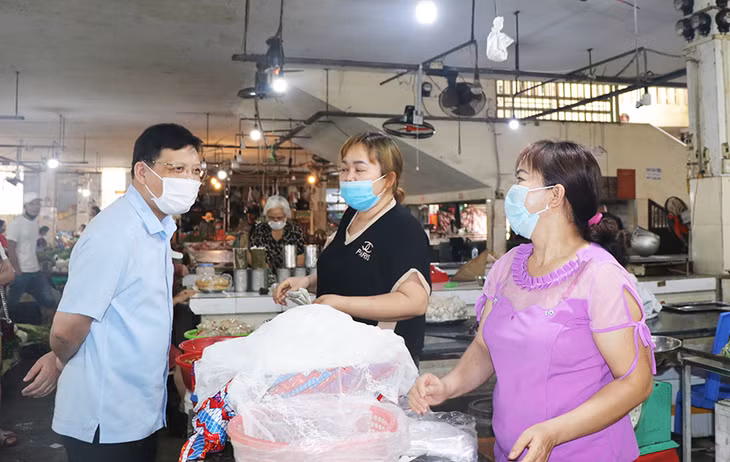 Bí thư Thành ủy Uông Bí Nghiên Xuân Cường truyên truyền cho tiểu thương chợ Thanh Sơn, TP Uông Bí về nguy cơ lây lan bệnh dịch Covid -19.