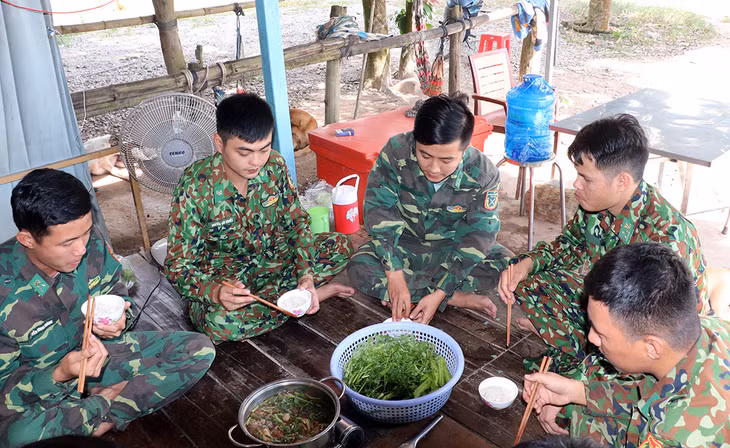 Chiến sĩ Đồn biên phòng cửa khẩu Long Bình, tỉnh An Giang thay phiên nhau ăn cơm trưa để tiếp trục túc trực tuần tra, kiểm soát biên giới. Ảnh: An Phú