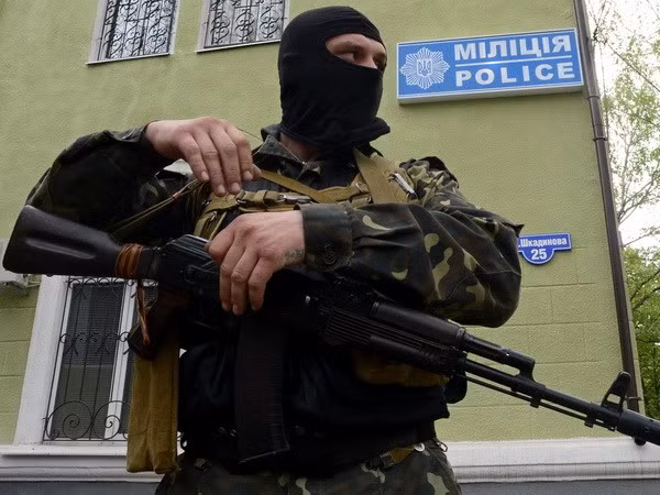 Một tay súng không rõ danh tính gác bên ngoài trụ sở cơ quan cảnh sát ở Kramatorsk ngày 22/4. (Ảnh: AFP/TTXVN)