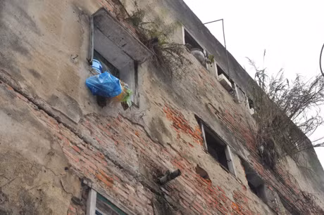 Bên ngoài các căn hộ vữa đã vỡ, trơ cả gạch