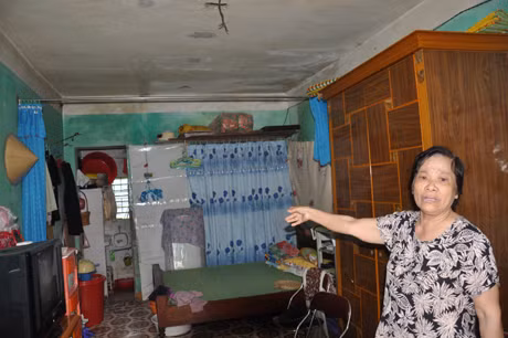 Bà Trần Thị Bích đang chỉ cho chúng tôi về tình trạng căn hộ đã xuống cấp của mình