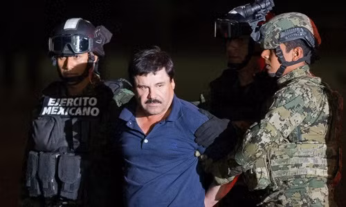 Binh sĩ quân đội và đặc nhiệm thuộc lực lượng thủy quân lục chiến Mexico hôm qua áp giải Guzman lên máy bay trực thăng. Ảnh: AP
