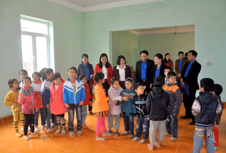 Các vị đại biểu và các em học sinh thăm công trình mới được hoàn thành.