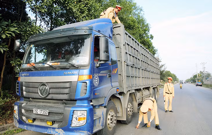 Đội CSGT Công an huyện Hoành Bồ kiểm tra kích thước thành thùng của phương tiện, tại đường 328 trên địa bàn xã Thống Nhất (Hoành Bồ), ngày 5-1-2016.