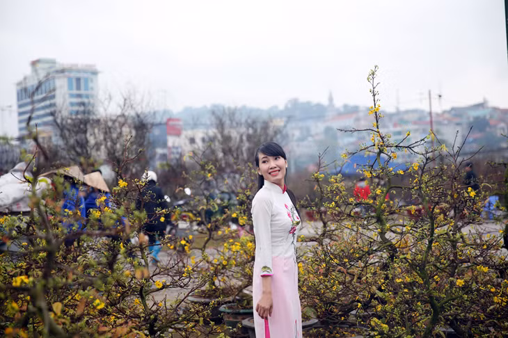 Thiếu nữ xinh tươi bên hoa mai vàng.