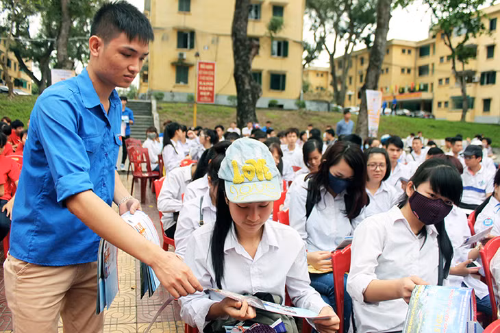 ĐVTN Trường ĐH Công nghiệp phát tờ rơi tư vấn, định hướng nghề nghiệp cho học sinh các trường THPT trên địa bàn TP Uông Bí. Ảnh: Bá Trinh (CTV)